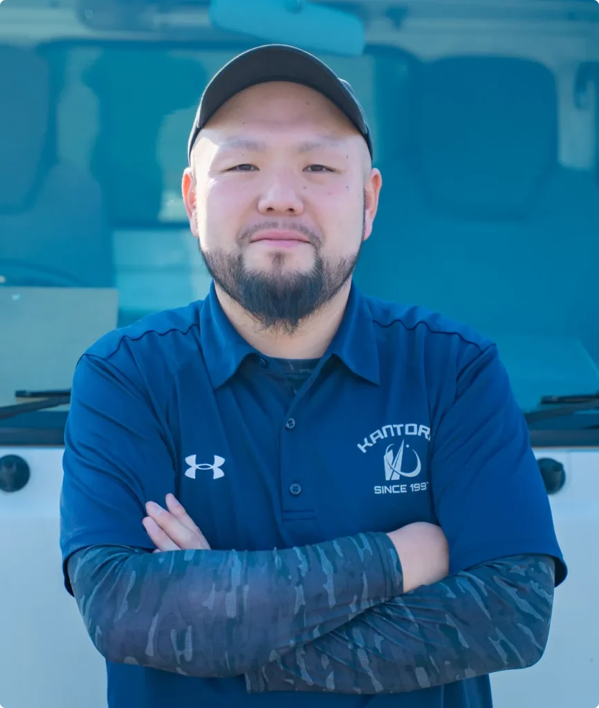 帽子をかぶり腕を組む作業者の正面姿