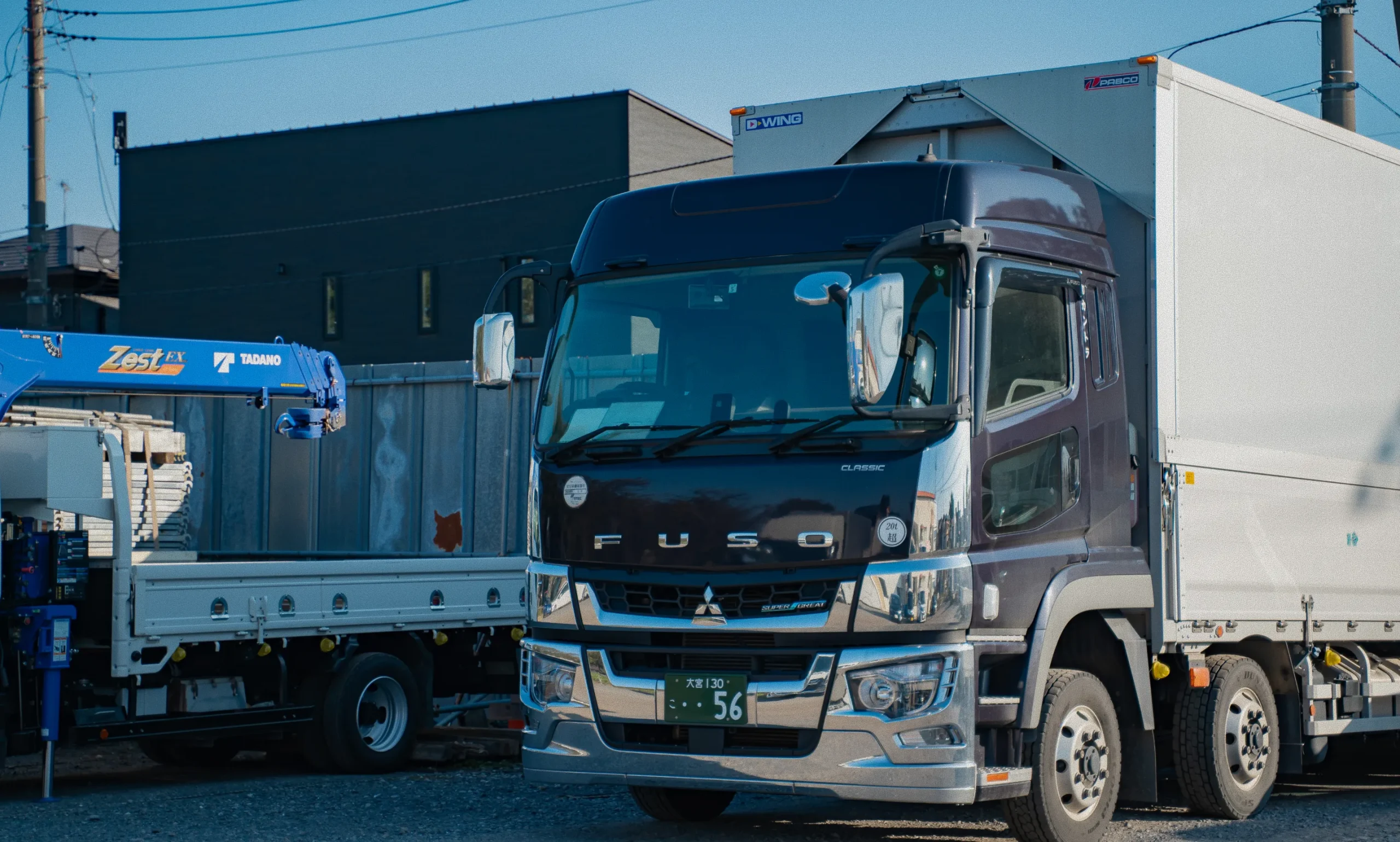 駐車場に停められた黒とシルバーの大型トラックの正面