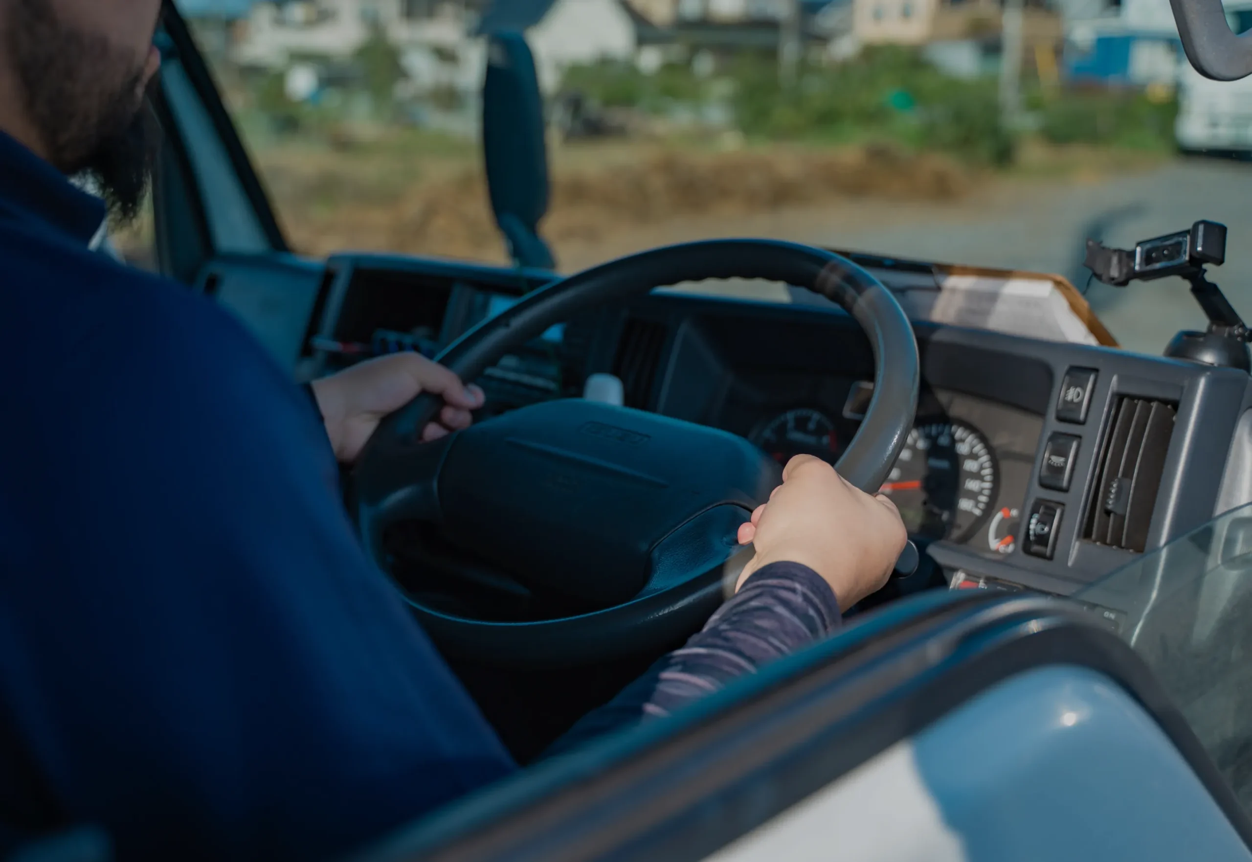 トラック運転席でハンドルを握る手元
