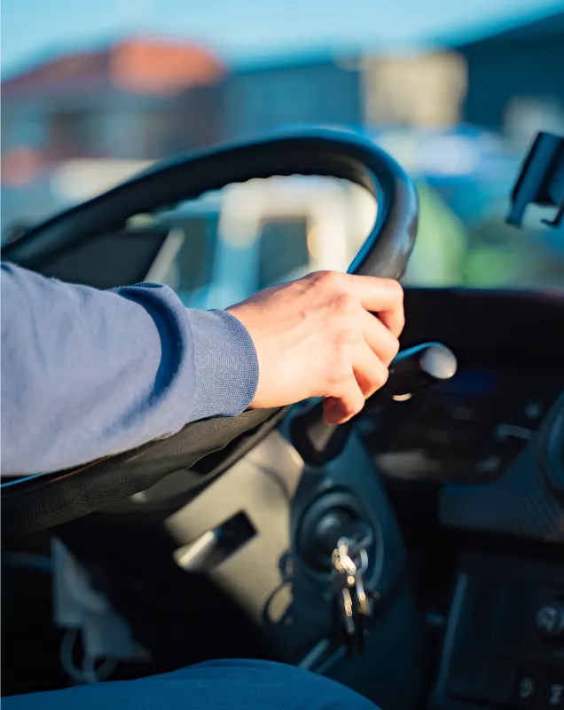 運転席でハンドルを握る手元のクローズアップ