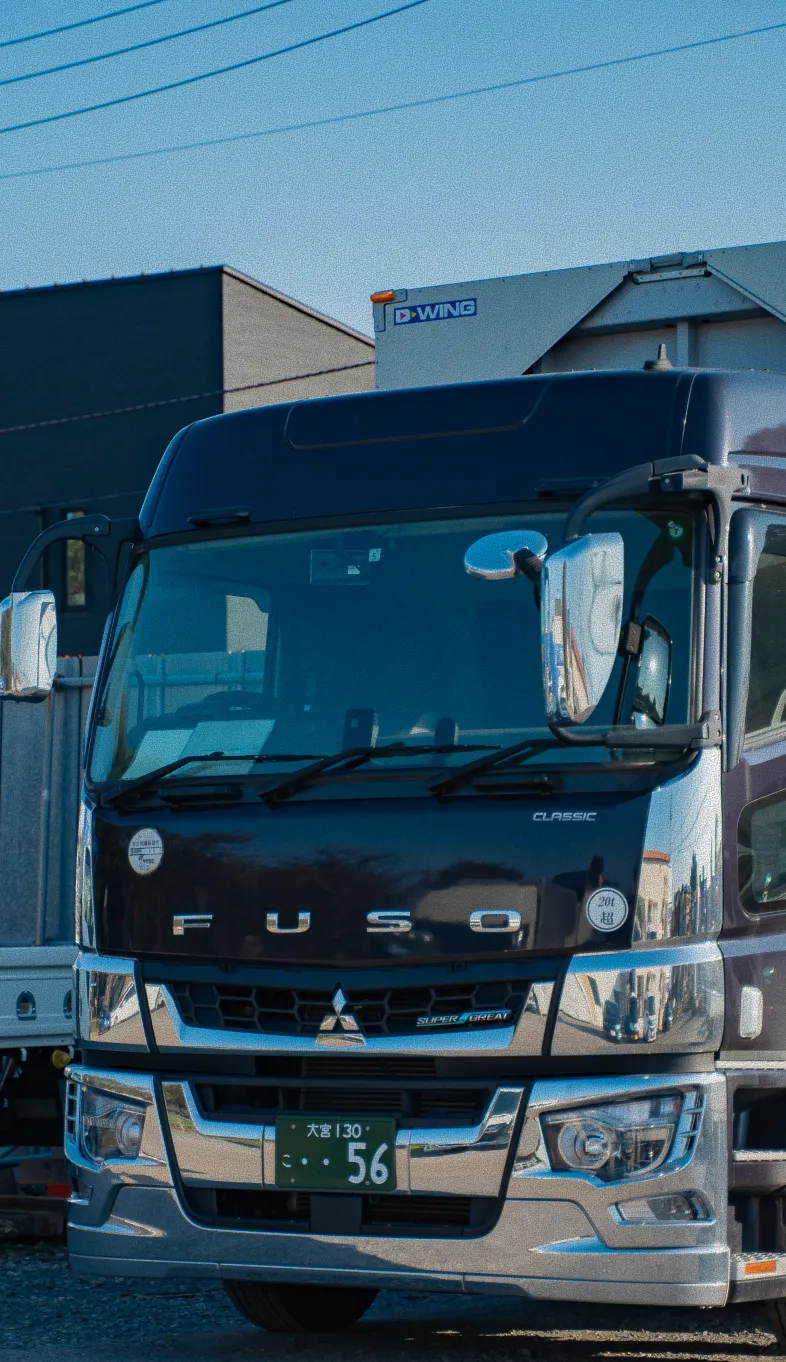 駐車場に停められた黒とシルバーの大型トラックの正面